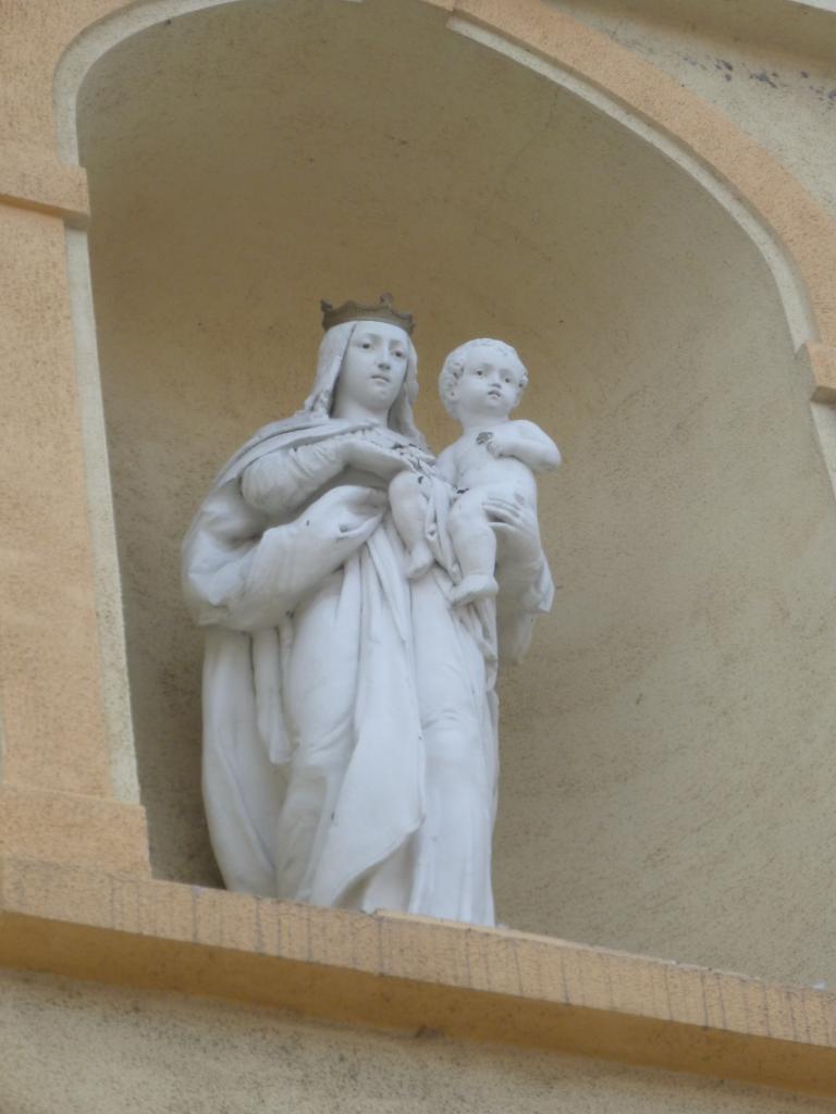 Szűz Mária-szobra a homlokzat fülkéjében