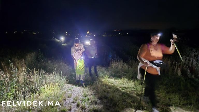 Haladás fejlámpával, háttérben a szőgyéni templom (Fotó: Berényi Kornélia/Felvidék.ma)